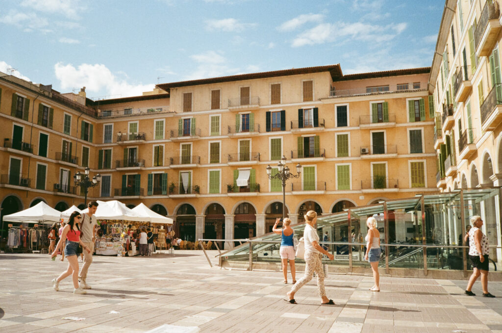 Analoges Foto eines gefüllten Platzes auf Mallorca. Geschossen mit der Olympus Mju II. Streetfotografie.